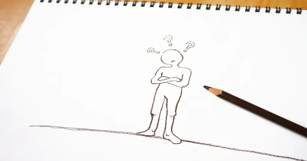 物忘れをしたために首を傾げる人を鉛筆書きした画用紙を撮影した写真