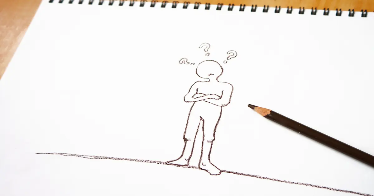 物忘れをしたために首を傾げる人を鉛筆書きした画用紙を撮影した写真