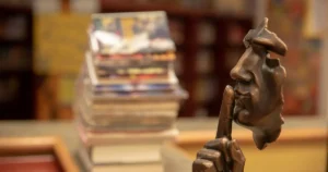 銅製の人物像が人差し指を口に当てて図書館で静かにするように促す画像
